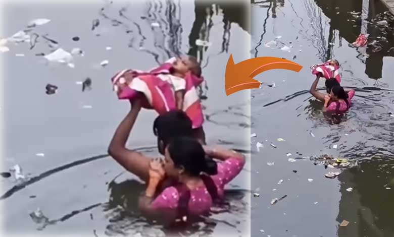 سیلاب میں والدین کا حوصلہ! ’باہوبلی‘ جیسا منظر، نومولود کو سر سے اوپر اٹھا کر پار کیا